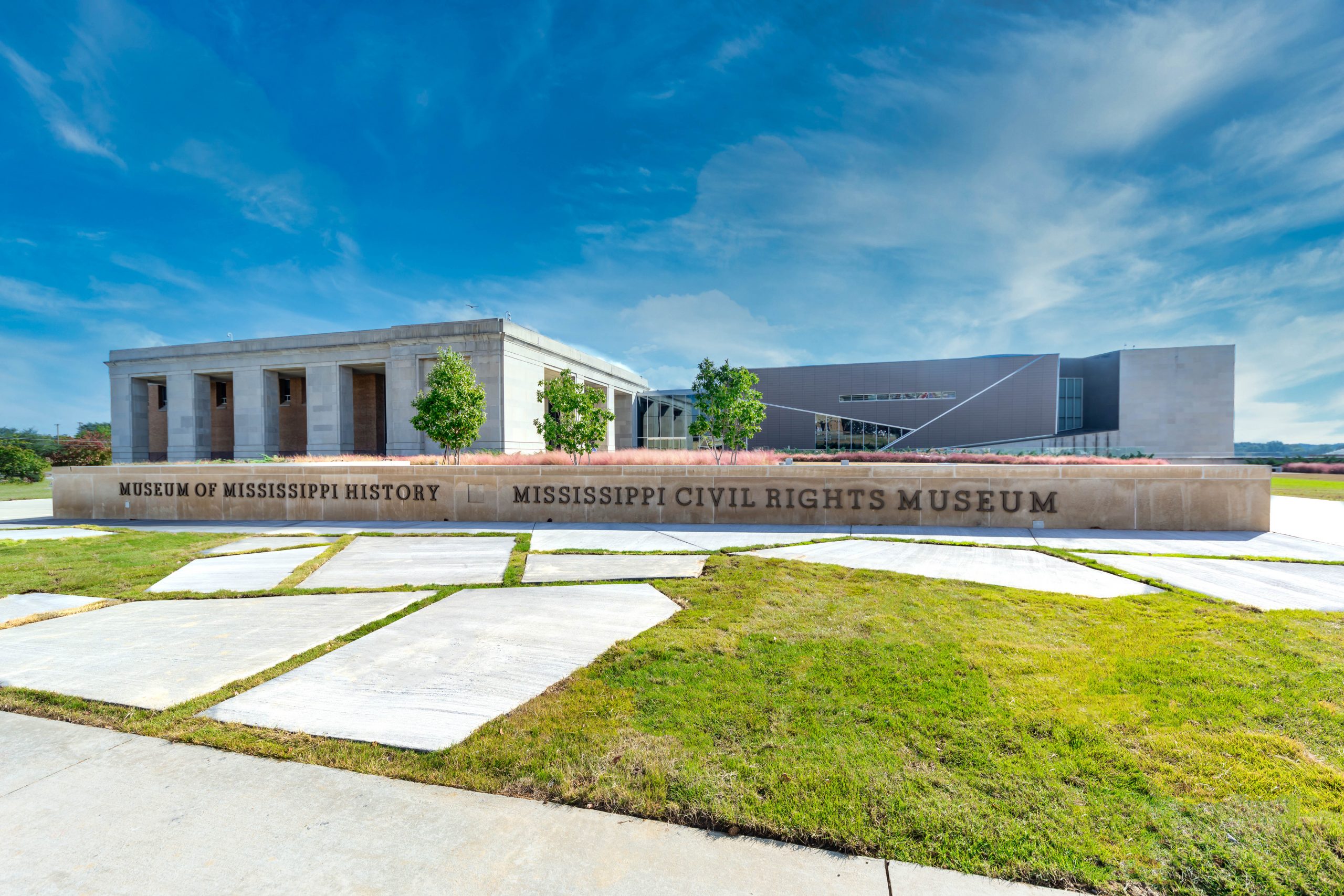 Exterior of the Museum of Mississippi History, Mississippi Department of Archives and History showing blue sky, a one story building, and in the foreground flagstone on a grass yard.