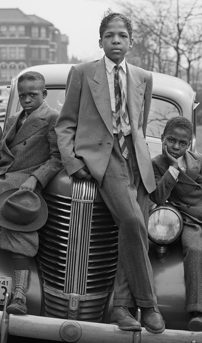 Kids in suits leaning on a car